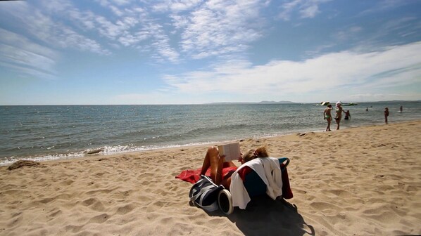 A sandy beach with people relaxing and reading. - 0015-BAHIA Apartment in front of the beach with wifi (Empuriabrava)