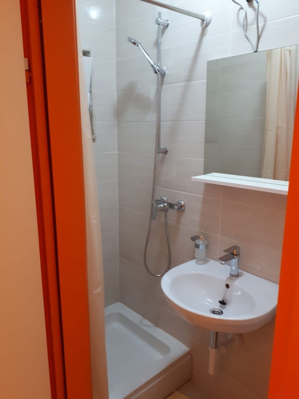 A bathroom with a shower, a sink, and a toilet.