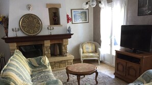 A living room with a fireplace, a television, and two armchairs. - Independent house, 3 bedrooms, 6 people, private pool in Lacanau ocean (LACANAU OCEAN)