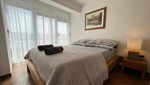 A neatly made bed with a quilt, two rolled towels, a bedside lamp, and a framed picture on the wall. - Apartment in Zaton (Zadar) with Terrace, Air condition, WIFI, Washing machine (4141-5) (Nin)