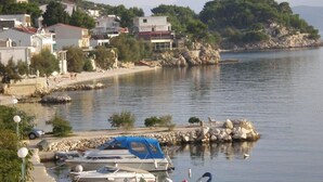 Un port de plaisance avec des bateaux amarrés, une côte rocheuse et des bâtiments en arrière-plan.