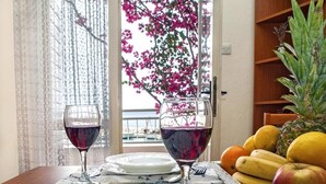 Une table à manger avec deux verres à vin, un plateau de fruits et une assiette.