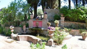 A garden with a stone wall, a small bridge, and various potted plants. - Villa in Uzzano with 4 bedrooms sleeps 10 (Uzzano)