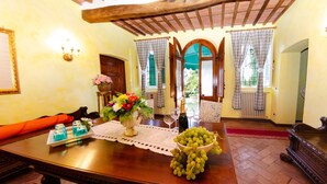 A dining area with a wooden table, a vase of flowers, and a bowl of grapes. - Villa in Uzzano with 4 bedrooms sleeps 10 (Uzzano)