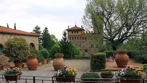 Ein Innenhof mit Steinbauten, großen Terrakottatöpfen und Kübelpflanzen.