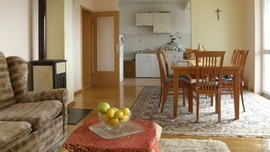 A living room with a sofa, a dining table with chairs, a kitchen in the background, and a cross on the wall. - Apartment in Duće with Seaview, Terrace, Air condition, Washing machine (595-1) (Duce)