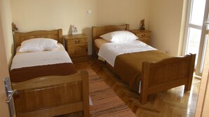 A room with two wooden beds, each with a nightstand and a drawer. The room has a wooden floor and a large window on the right side. - Apartment in Duće with Seaview, Terrace, Air condition, Washing machine (595-1) (Duce)