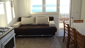 A compact living space with a sofa, a dining table, and a kitchen area. - Apartment in Duće with Seaview, Balcony, Air condition, WIFI (237-1) (Duce)