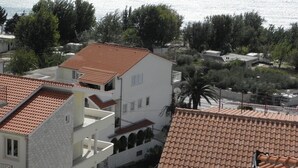 A coastal residential area with terracotta-tiled roofs, white buildings, and a view of the sea. - Apartment in Duće with Seaview, Balcony, Air condition, WIFI (237-1) (Duce)