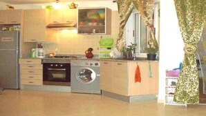 Une cuisine compacte équipée d’un lave-linge, d’une cuisinière et d’un four à micro-ondes.