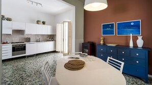 Une cuisine moderne avec des meubles blancs, une cuisinière et un coin repas comprenant une table et des chaises.