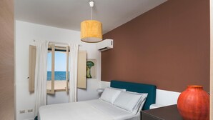 Une chambre à coucher avec un lit, une table de chevet, un vase et une fenêtre avec des rideaux.