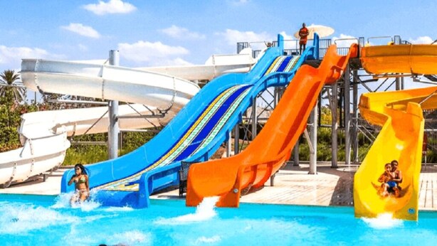 Parque acuático con múltiples toboganes y una piscina.