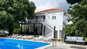 A two-story house with a swimming pool, outdoor seating, and a covered patio. - Apartment in Bibinje with Terrace, Air condition, WIFI, Washing machine (877-2) (Bibinje)