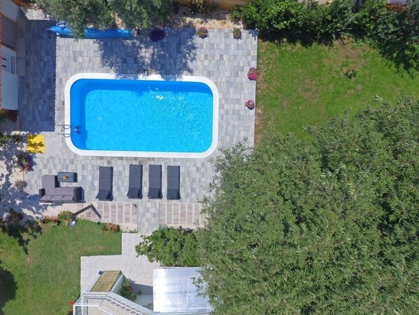 An aerial view of a swimming pool with adjacent lounge chairs and a covered patio area. - Apartment in Bibinje with Terrace, Air condition, WIFI, Washing machine (877-2) (Bibinje)
