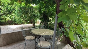 A round metal table with four chairs, surrounded by a garden with various plants and trees. - Apartment in Bol with Terrace, Air condition, WIFI, Washing machine (3634-4) (Bol)
