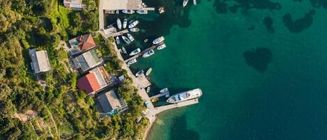 An aerial view of a coastal area with a marina, boats, and residential buildings.