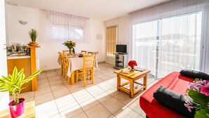 Een modern appartement met een eetgedeelte, keuken, woonkamer en balkon.