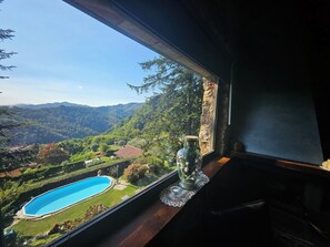 Une chambre avec vue sur une piscine et sur les montagnes.