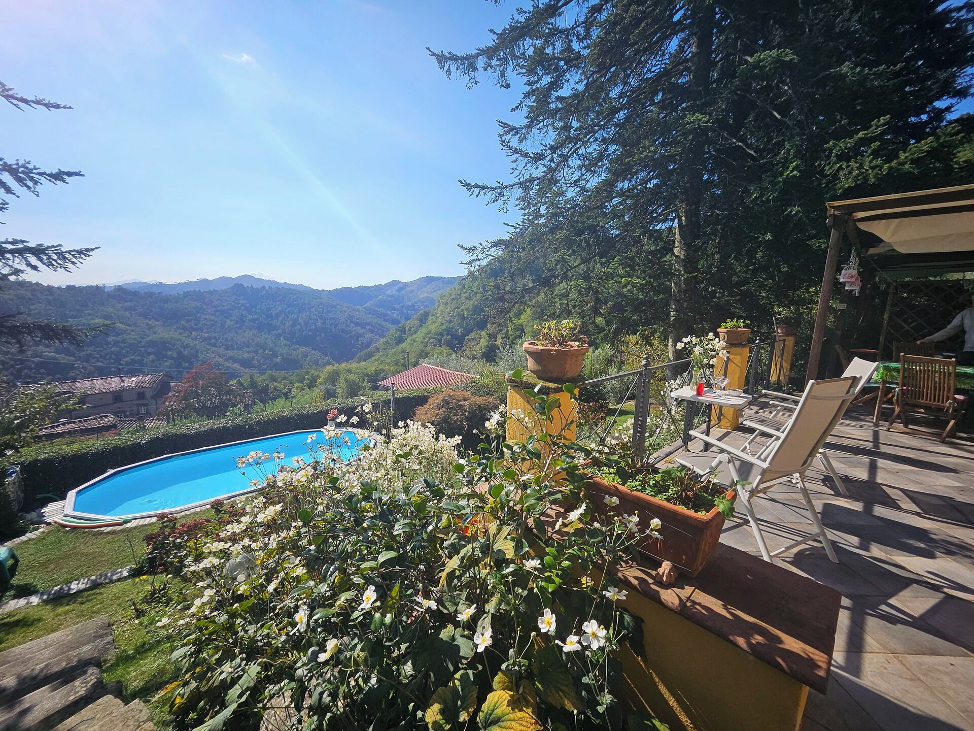 Ein Schwimmbecken, umgeben von üppigem Grün mit Blick auf ferne Berge.
