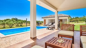 A poolside area with a clear view of the pool, lounge chairs, and a covered seating area. - Holiday Home in Buje with Terrace, Air condition, WIFI, Washing machine (3356-1) (Buje)