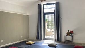 A yoga room with mats and pillows, a statue, and a view through a window with curtains. - Villa in San Concordio Di Moriano with 6 bedrooms sleeps 12 (Lucca)