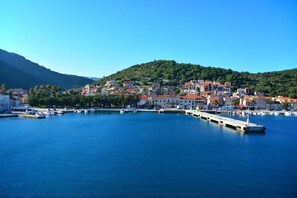 A coastal town with a marina, buildings with red roofs, and a hilly backdrop. - Holiday Home in Vis with Terrace, Air condition, Dishwasher (139-1) (Vis)