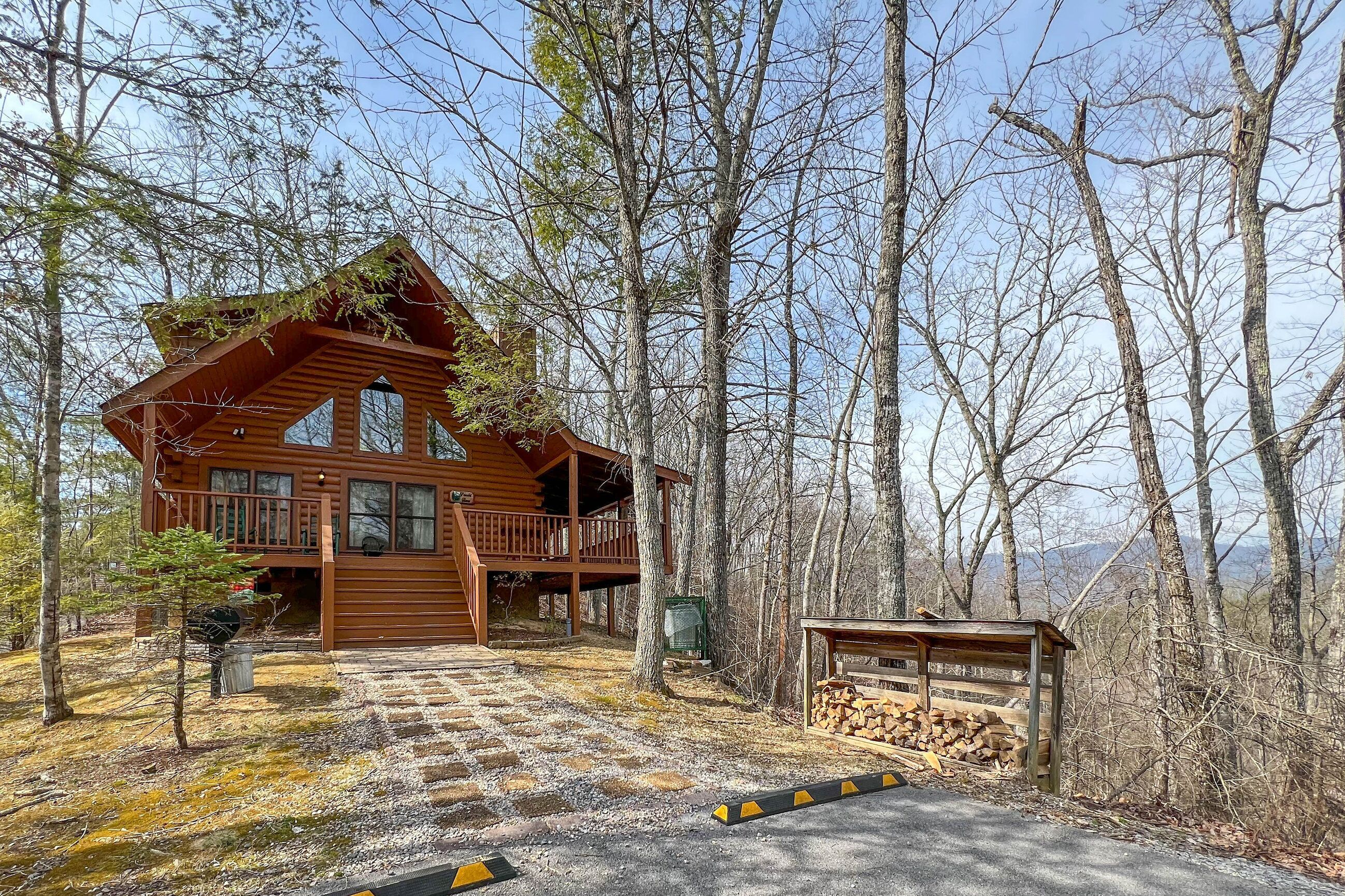 A wooden cabin with a balcony, surrounded by trees and a clear sky.