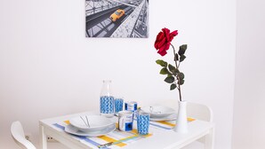 Ett matbord med tallrikar, koppar och en vas med en ros.