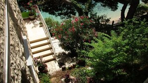 A stone building with a staircase leading to a balcony overlooking a body of water. - Apartment in Pisak with Seaview, Terrace, Air condition, WIFI (196-1) (Pisak)