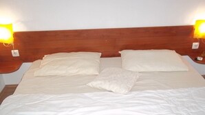 A bed with a wooden headboard, two bedside lamps, and a single pillow. - Apartment in Vodice with Terrace, Air condition, WIFI (3599-8) (Vodice)