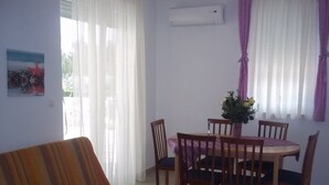 A living room with a sofa, a dining table with chairs, and a window with curtains. - Apartment in Vodice with Terrace, Air condition, WIFI (3599-8) (Vodice)