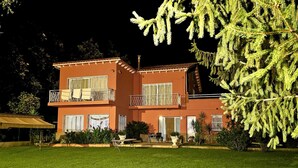 A two-story building with balconies, a lawn, and a large tree. - Villa Romera Rural Cottage for 25 people (Cardedeu)
