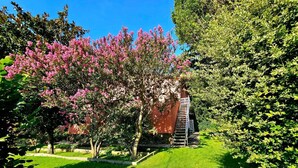 A well-maintained garden with a pathway leading to a building with a red facade and a white staircase. - Villa Romera Rural Cottage for 25 people (Cardedeu)