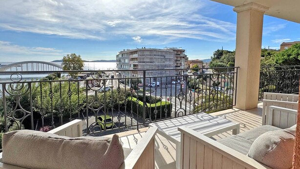 Ein Balkon mit Blick auf eine Stadtlandschaft, darunter eine Brücke und Gebäude.