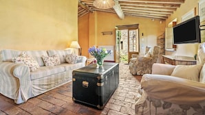 A cozy living room with a sofa, armchair, and a vintage suitcase on a brick floor. - Villa in Torcigliano with 5 bedrooms sleeps 10 (Torcigliano)