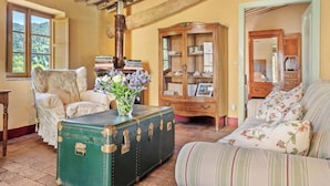 A room with a green trunk, a floral sofa, a wooden cabinet, and a window with a view. - Villa in Torcigliano with 5 bedrooms sleeps 10 (Torcigliano)