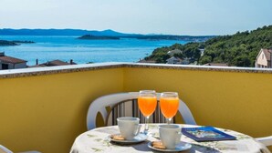 A balcony with a table set for breakfast, overlooking a scenic coastal view. - Apartment in Drage with Seaview, Balcony, Air condition, WIFI (566-1) (Drage)