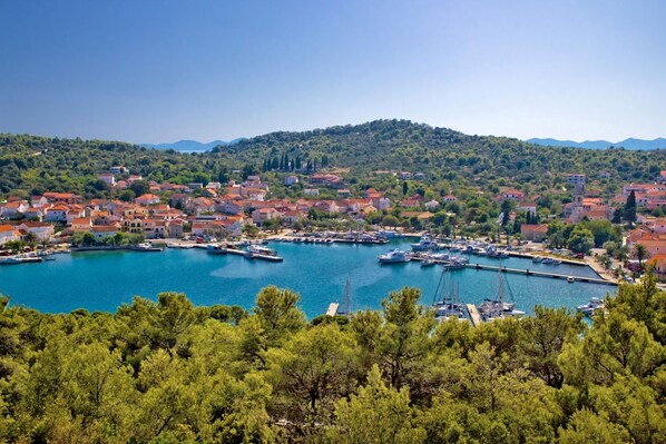 Experience the charm of a bustling marina surrounded by lush greenery and Mediterranean-style buildings.