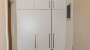 A white wardrobe with two doors and two drawers, a small window, and a door handle.