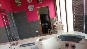 A bathroom with a pink and black tiled wall, a shower, and a sink. - Mudayyan house for couples or small families. (Coca de Alba)
