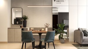 A modern living room with a sofa, a dining table with chairs, a large mirror, and a potted plant. - Saigon Royal Tower! (Ho Chi Minh)