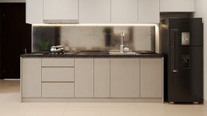 A modern kitchen with a stainless steel refrigerator, a built-in oven, and a sleek countertop. - Saigon Royal Tower! (Ho Chi Minh)