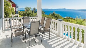 A covered outdoor area with a table and chairs, overlooking a scenic view of the sea and distant mountains. - Apartment in Crikvenica with Seaview, Terrace, Air condition, WIFI (3492-2) (Crikvenica)