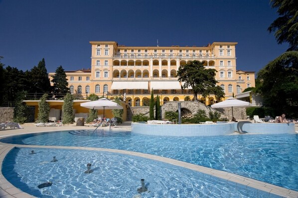A large pool area with multiple swimming pools and sun loungers, surrounded by a building with multiple balconies and a stone bridge. - Apartment in Crikvenica with Seaview, Terrace, Air condition, WIFI (3492-2) (Crikvenica)