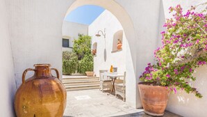 An outdoor seating area with a table and chairs, a large vase, and potted plants. - Country Resort in Torre Suda with 2 bedrooms sleeps 4 (Torre Suda)