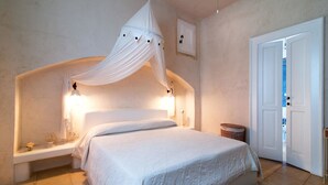 A bedroom with a canopy bed, bedside lamps, a bedside table, and a door. - Country Resort in Torre Suda with 2 bedrooms sleeps 4 (Torre Suda)