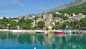 A coastal town with buildings along the waterfront, a marina with boats, and a clear blue sea. - Apartment in Brela with Seaview, Terrace, Air condition, WIFI (75-3) (Brela)