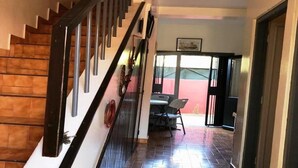 Un escalier menant à une salle à manger avec une table et des chaises.