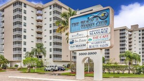 Señal para The Beach Club Tennis Condominium con servicios como Royal Shell Vacation Rentals, Barefoot Massage, Bay Pointe, The Cafe at Bonita Beach, Sea Breeze Beauty Salon y Maxim Maxim Real Estate.
